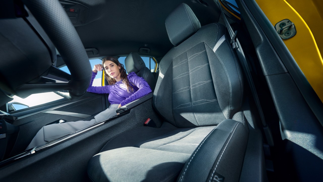 Sièges avant noirs d'une Opel Astra Electric avec une femme assise sur le siège passager